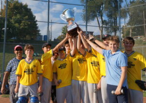 Following their 15-8 victory over the Crawfords, a jubilant group of Homesteads players hoist the TPBA House League Tournament 18U Varsity Division Championship Trophy at Dominico Field at Christie Pits.