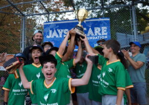 Following their miracle come from behind 8-7 victory over the Expos, jubilant A's players and coaches hoist the TPBA 11U House League Tournament 11U Mosquito Division Championship Trophy at Christie Pits Diamond 3.
