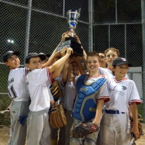 Following their 16-13 extra inning victory over the Dodgers, a jubilant group of Marlins players hoist the TPBA 13U House League Tournament 13U Peewee Division Championship Trophy at Christie Pits Diamond 2.