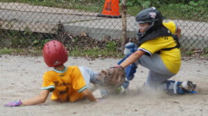 In a chitty chitty bang bang play, Yankees catcher Van (9) tags out Mariners baserunner Mateo (7) to thwart his bid to steal home during a 2026 TPBA House League Baseball 11U Mosquito Division Tournament Round Robin Game at Bickford Park Diamond.